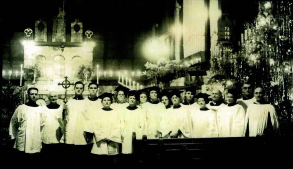 Clergy and choir vested before the decorated altar at Christmas
